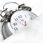 Hand holding black machined steel mechanical pencil with brass tip and top.